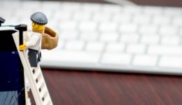 BAM Agency Two toy figures in thief outfits climb a ladder against a smartphone displaying the Facebook login page, alluding to the Facebook scandal. A computer keyboard and mouse are blurred in the background, subtly suggesting how such events might affect your online security awareness. BAM Agency