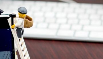 BAM Agency Two toy figures in thief outfits climb a ladder against a smartphone displaying the Facebook login page, alluding to the Facebook scandal. A computer keyboard and mouse are blurred in the background, subtly suggesting how such events might affect your online security awareness. BAM Agency