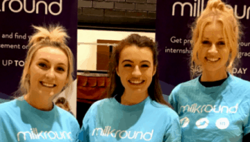 BAM Agency Three people, bright smiles on their faces, don blue Milkround T-shirts as they stand proudly before Milkround banners. Theyre ready to connect freshers with exciting graduate job opportunities against the backdrop of a dark brick wall. BAM Agency