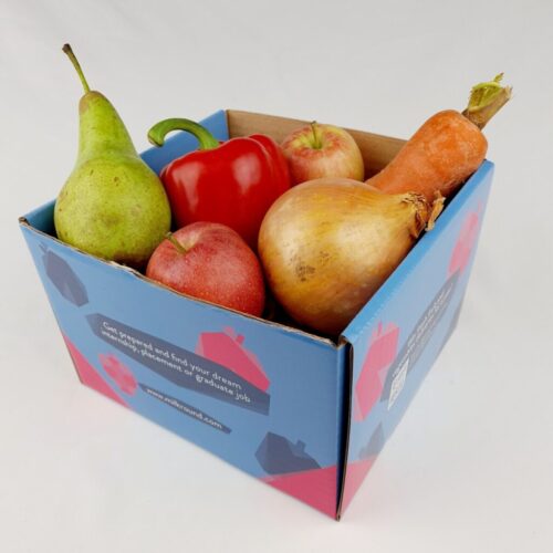 A box containing a pear, red bell pepper, apple, pomegranate, onion, and butternut squash. The box is blue with text and graphics. BAM Agency