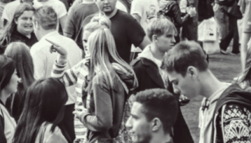 BAM Agency A black and white photo captures a bustling crowd outdoors, where influencers of all ages mingle casually. Men and women engage in lively conversations, embodying the spirit and reasons behind this vibrant gathering. BAM Agency