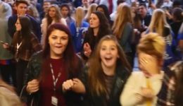 BAM Agency A large crowd of excited young people, mostly women, are gathered closely together at the successful Freshers campaign. Some are smiling and holding phones, capturing the lively atmosphere. The background shows more individuals mingling in a bustling environment. BAM Agency