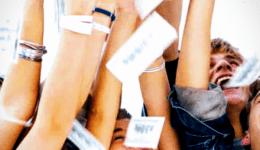 BAM Agency A group of University students joyfully throwing money into the air. Their arms are raised, and they are smiling and laughing. The background is bright, creating an energetic and lively atmosphere. BAM Agency