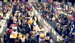 BAM Agency A wide-angle view of a bustling convention hall unfolds, offering fresh insight into the vibrant world of networking. Packed with people exploring booths, various banners and displays create an energetic atmosphere. BAM Agency