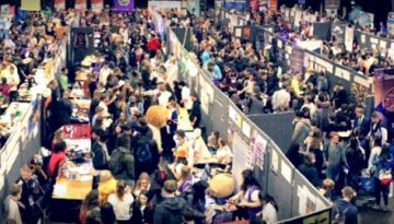 BAM Agency A wide-angle view of a bustling convention hall unfolds, offering fresh insight into the vibrant world of networking. Packed with people exploring booths, various banners and displays create an energetic atmosphere. BAM Agency