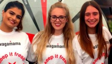 BAM Agency Five people stand in a line, smiling at the camera. Four are wearing white wagamama shirts, while the person on the right sports black. The scene captures a vibrant moment from the Freshers Tour with a wagamama logo visible on the top right. BAM Agency