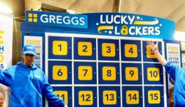 BAM Agency Two people in blue Greggs uniforms stand beside the Lucky Lockers game board, numbered 1 to 12. Perfect for advertising at university campuses and Freshers Fairs, signs offer a free sandwich for new app sign-ups. They smile and pose with arms raised, engaging passersby effortlessly. BAM Agency