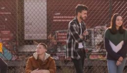 BAM Agency Five people are socializing by a chain-link fence with graffiti-covered train cars in the background. One person is sitting while the others stand, embodying a relaxed and upbeat vibe that speaks to the youthful energy important to todays brand-driven market. BAM Agency