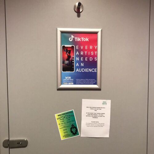 A door displays three papers: a colorful TikTok poster with the phrase Every Artist Needs an Audience, a green flyer about salsa and bachata classes, and a white printout with rules for mobile devices during events. BAM Agency