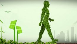 BAM Agency A figure made of green foliage, embodying environmentally aware millennials, walks alongside wind turbines and solar panels. In the background, industrial factories and oil pumps emit smoke, contrasting sustainable energy with traditional industry. The sky is overcast, with birds flying overhead. BAM Agency