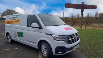 BAM Agency A white Volkswagen van with Turn your passion into a career. Teach. printed on its side is parked by the roadside. The Angel of the North sculpture stands in the background under a partly cloudy sky. BAM Agency